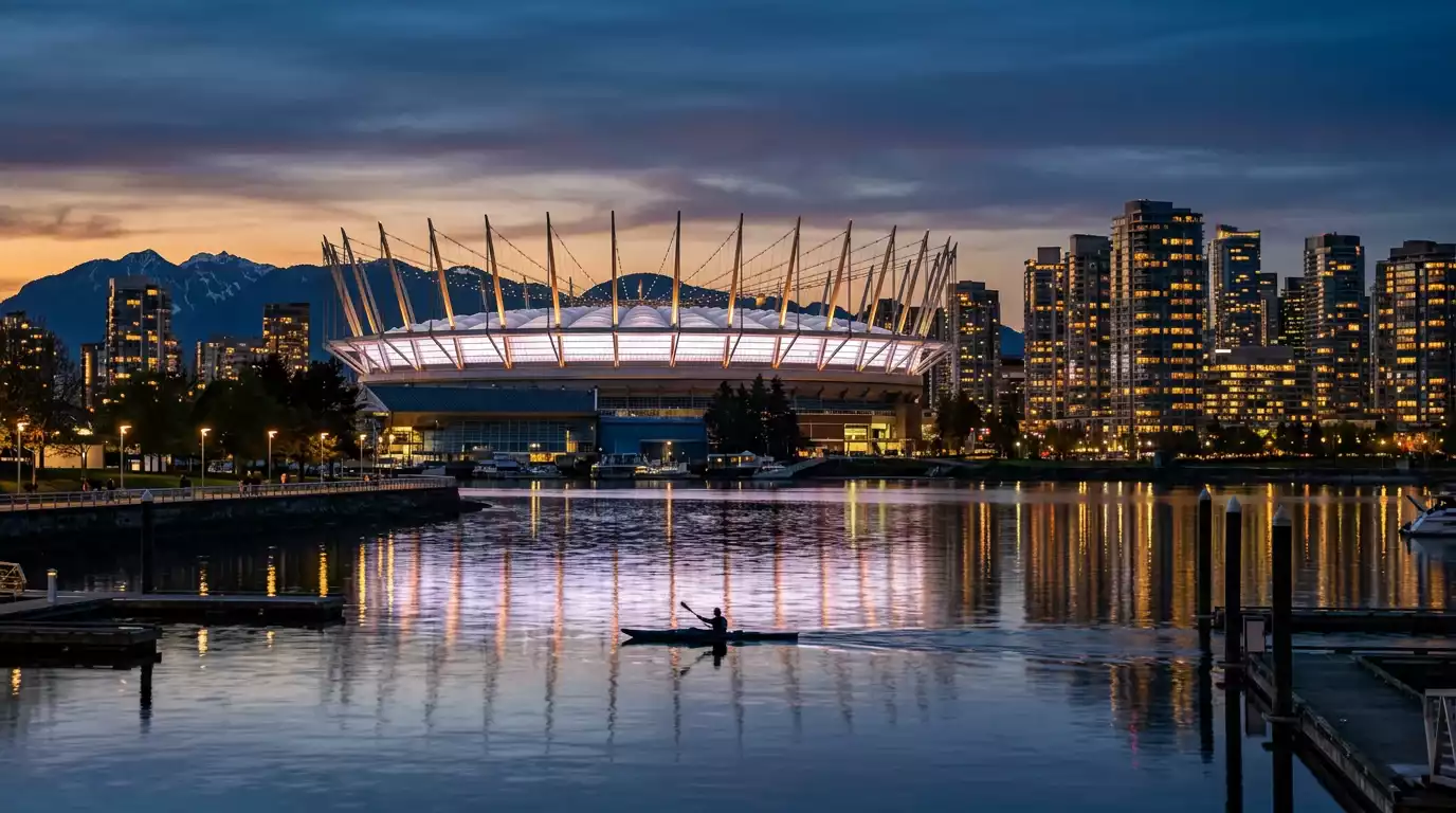 BC Place de Vancouver photographié au crépuscule, toit rétractable blanc en forme de couronne, gratte-ciel du centre-ville et silhouette des montagnes côtières en arrière-plan