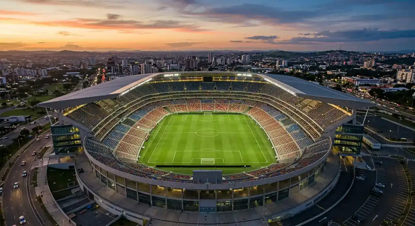 Vue plongeante d'un grand stade vide avec le terrain éclairé, lignes blanches nettes, sièges multicolores, ciel crépusculaire